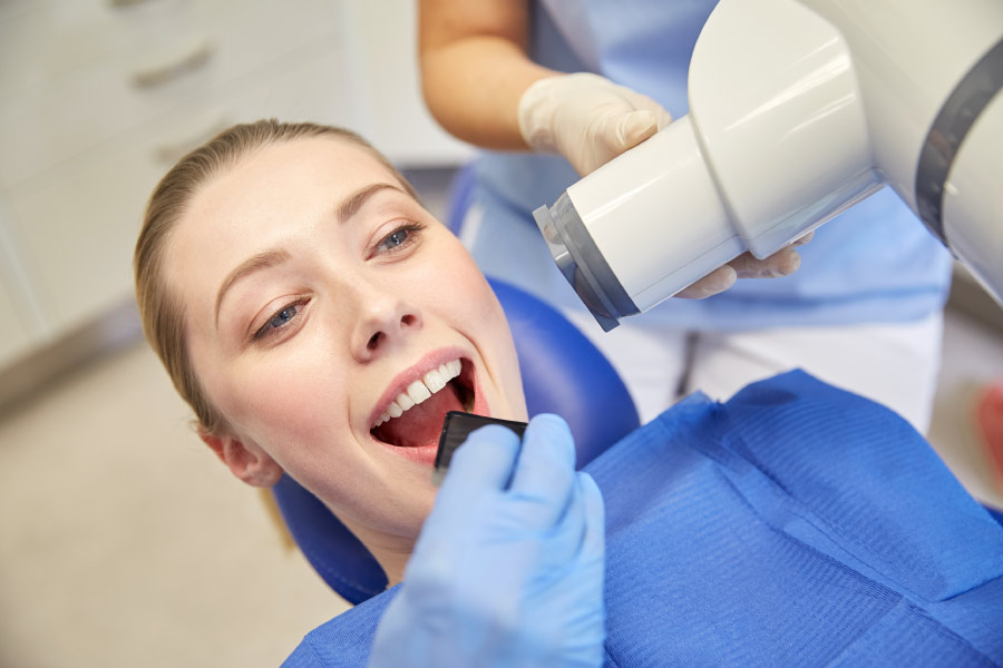 Young woman in a dental chair preparing to get a digital X-ray.