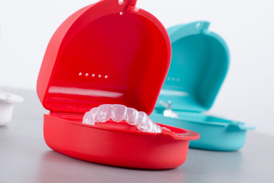 Colorful cases filled with Invisalign clear aligners.