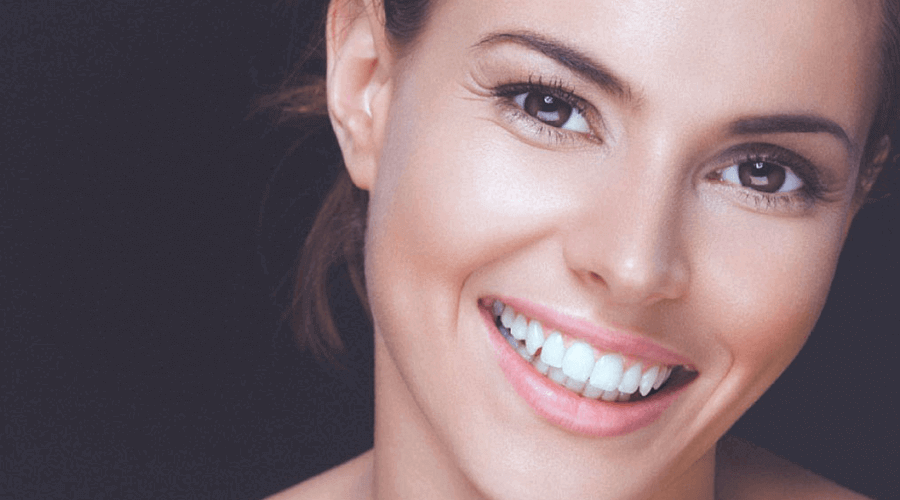Close up of a pretty browned eyed smiling brunette woman
