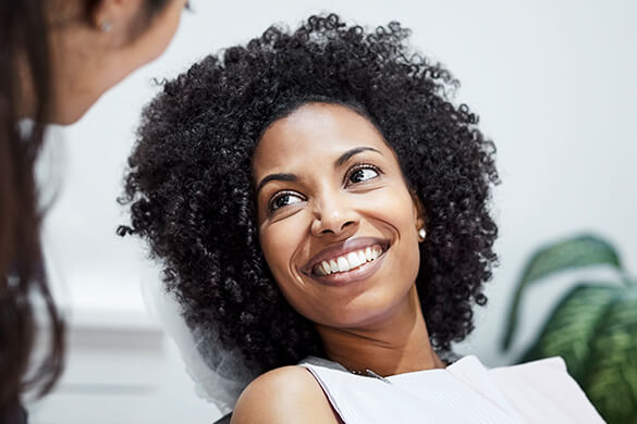 smiling woman speaking with her dentist