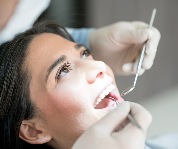 woman having her teeth examined by a dentist