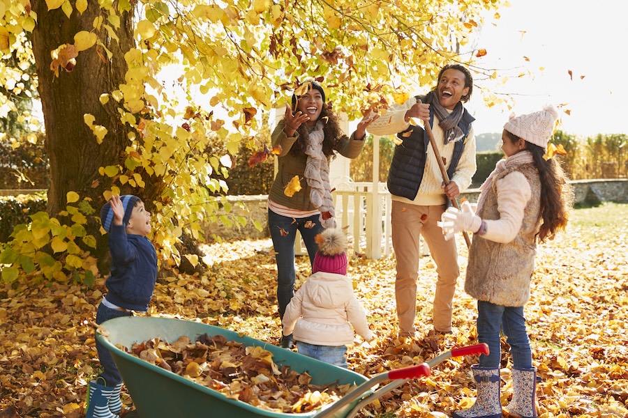 family playing in fall leaves, need to use dental benefits in the fall